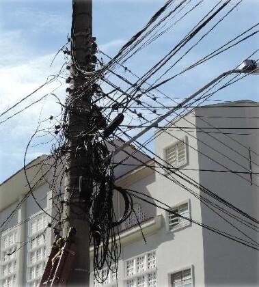 Fios inservíveis pendurados em postes 