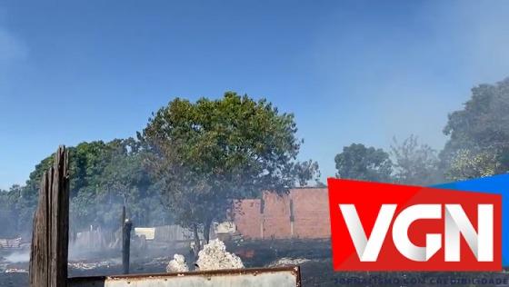 Terreno pega fogo e moradores tentam apagar chamas. 