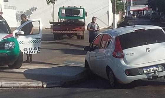 O automóvel além de cair no bueiro furou o pneu traseiro.