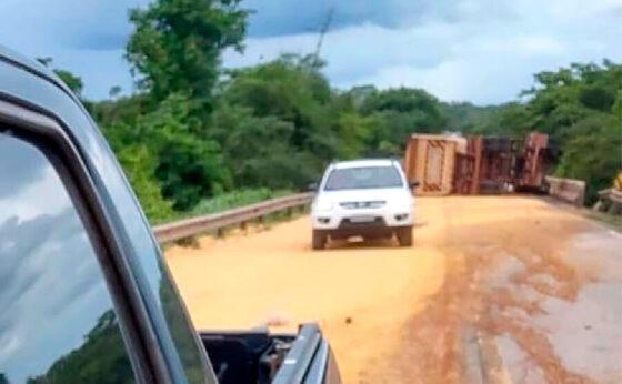 Carreta carregada de milho tomba em cabeceira de ponte em MT.