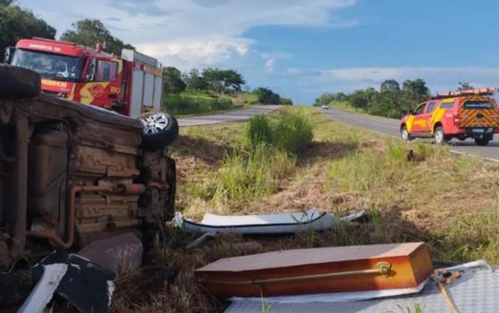 Carro de funerária capota, mata motorista e deixa caixão espalhado pela rodovia