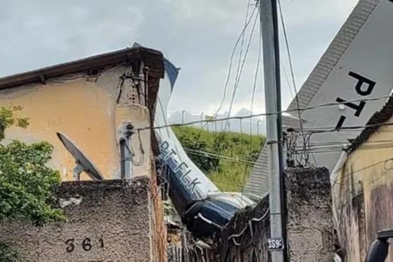 Avião cai sobre casas e dois tripulantes ficam feridos