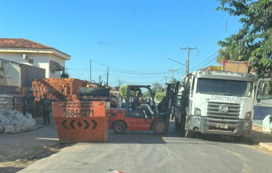 A vizinha enviou fotos que mostram caçamba, caminhão, tijolos e empilhadeira obstruindo a pista